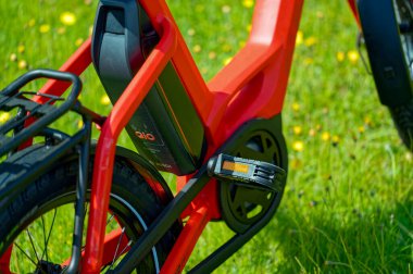 Berlin, Almanya - 22 Mayıs 2023: Çiçek çayırının ortasında kırmızı bir bisikletin detayları.