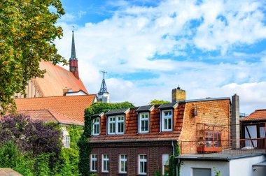 View to facades of historic buildings in Salzwedel, Germany, under a blue sky.