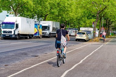 Berlin, Almanya - 30 Temmuz 2023: Berlin 'de bisikletçiyle sokak sahnesi. Bisiklet yolu bisikletçilere trafikte daha fazla yer vermek için boyandı.