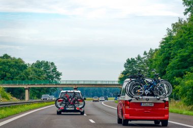 24. Otoyol, Almanya - 12 Ağustos 2023: Kıça bağlı bisikletli arabalar ve bisikletler.