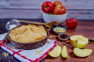 Mutfak tezgahında malzemeler ve mutfak gereçleriyle taze pişmiş elmalı turta..