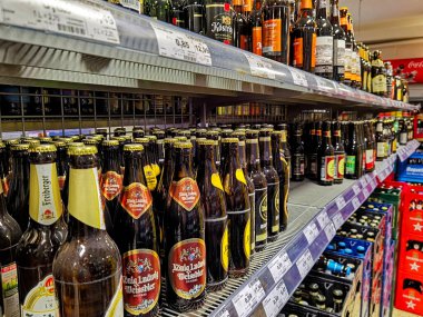 Berlin, Almanya - 19 Ekim 2021: Süpermarkette bira şişeleriyle dolu bir rafa bakın.