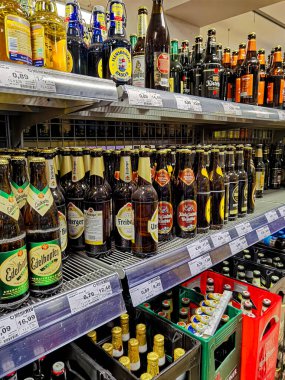 Berlin, Almanya - 19 Ekim 2021: Süpermarkette bira şişeleriyle dolu bir rafa bakın.