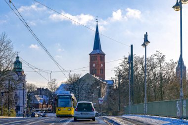 Berlin, Almanya - 19 Ocak 2024: Berlin-Kpenick 'te tarihi St. Laurentius Kilisesi önünde tramvaylı kış manzarası.