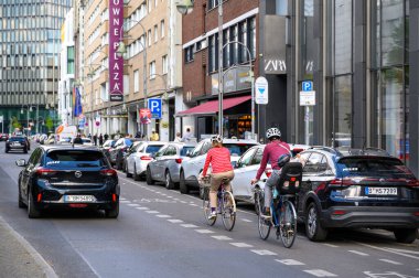 Berlin, Almanya - 27 Nisan 2024: Berlin 'in merkezinde boyalı bisiklet yolunda iki bisikletçi ile sokak sahnesi.