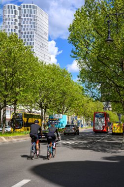 Berlin, Almanya - 27 Nisan 2024: Berlin 'deki Kurfuerstendamm' da arkadan iki sportif giyimli bisikletçi.