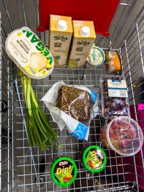 Berlin, Almanya - 10 Mayıs 2024: Çeşitli ürünlerle birlikte bir alışveriş arabasına bakın.