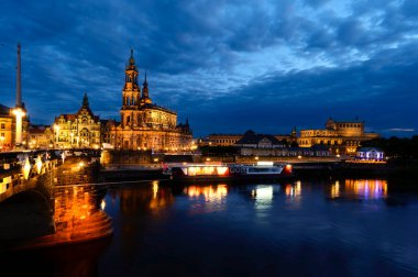 Dresden 'in parlak ışıklı tarihi binalarının Elbe' ye renkli yansımalarının gece çekimi..