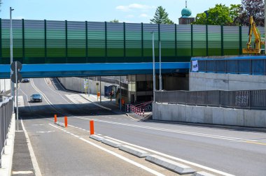 Berlin, Almanya - 25 Temmuz 2024: Berlin 'in güneyindeki Dresdner Bahn köprüsünün altından geçen bisiklet yolu ve kaldırımı olan modern cadde.