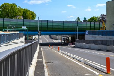 Berlin, Almanya - 25 Temmuz 2024: Berlin 'in güneyindeki Dresdner Bahn köprüsünün altından geçen bisiklet yolu ve kaldırımı olan modern cadde.