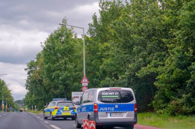 Dresden, Almanya - 11 Haziran 2024: Bir polis aracının eşlik ettiği adalet aracı.