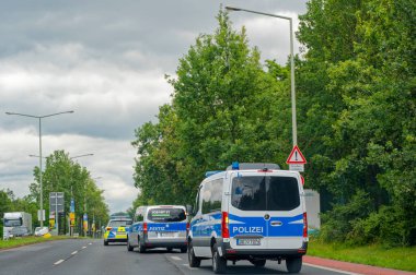 Dresden, Almanya - 11 Haziran 2024: Bir adalet aracına iki polis arabası eşlik ediyor.