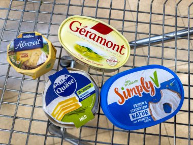 Berlin, Almanya - 17 Eylül 2024: Çeşitli peynir ürünleriyle bir alışveriş arabasına bakın.