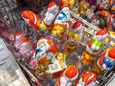 Berlin, Almanya - 27 Kasım 2024: Süpermarkette bir raf dolusu çikolatalı Noel Baba.