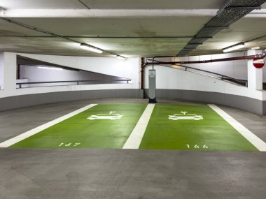 Otoparkta pillerini şarj edebilen elektrikli arabalar için işaretlenmiş iki park yeri var. Şarj istasyonu çalışmıyor..