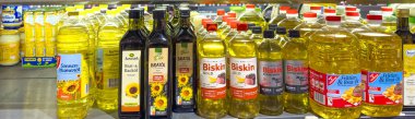 Berlin, Almanya - 19 Aralık 2024: Süpermarkette çeşitli şişelerde pişirme yağı bulunan raf. 