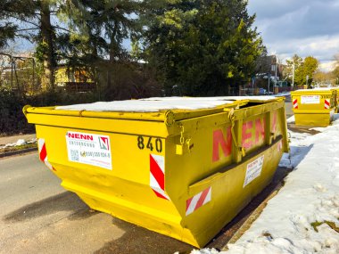 Berlin, Almanya - 17 Şubat 2025: Kış sokağının yol kenarındaki enkaz konteynırı.