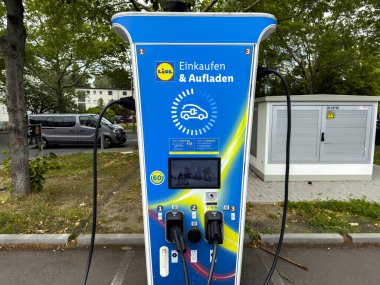 Berlin, Almanya - 11 Temmuz 2025: İndirimli bir marketin otoparkındaki elektrikli araçlar için şarj istasyonu.
