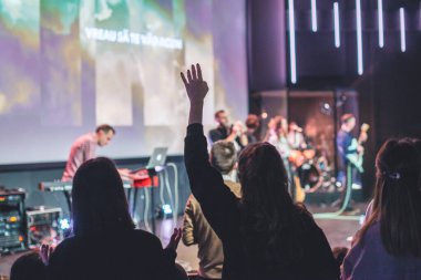 Kilise ayininde Tanrı 'ya şükreden bir kadının elleri havada.