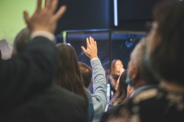 Kilise ayininde Tanrı 'ya şükreden insanların elleri havada.