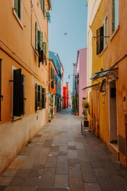 Burano, İtalya - Ekim 2022: Burano 'da teknesi olan kanal önündeki tipik renkli evler