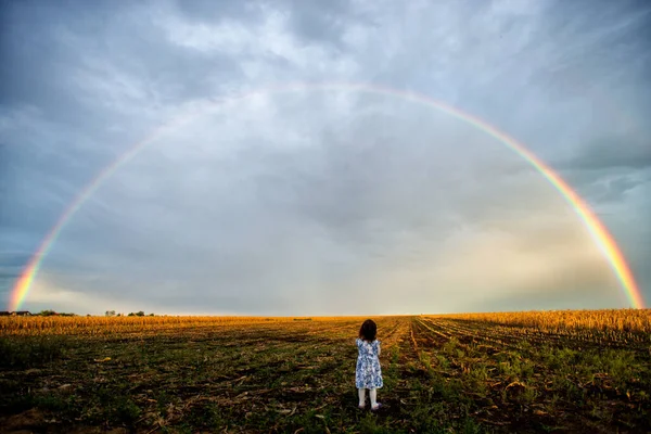 Kleines Mädchen Steht Draußen Und Bewundert Einen Vollen Regenbogen Himmel — Stockfoto
