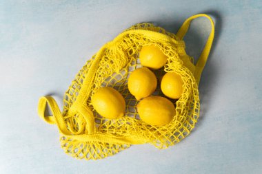 Sarı market çantasındaki organik limonlar. Üst görünüm 