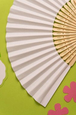 Geleneksel beyaz el yelpazesini yaz modeli için katlıyorum. Yeşil arkaplan