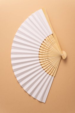Geleneksel beyaz el yelpazesini yaz modeli için katlıyorum. Bej arkaplan