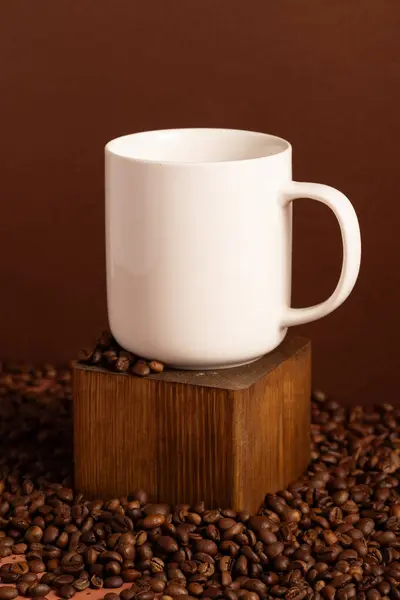 Blank white mug mock-up on brown background with coffee beans