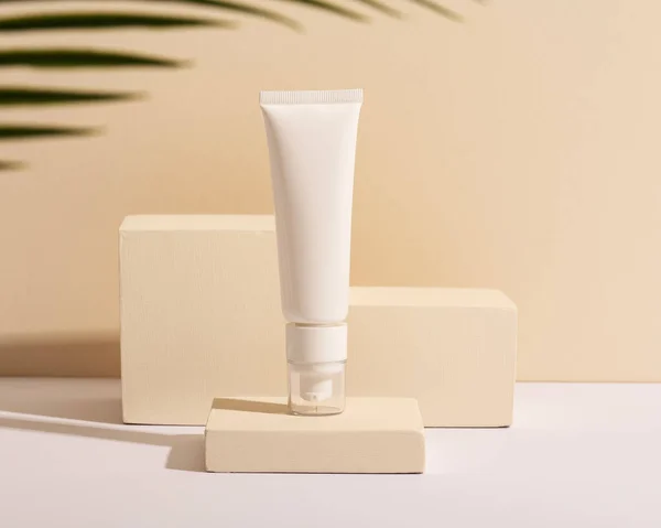 Serum blank white packaging against a beige background, podiums, skincare cosmetics