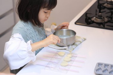 Japanese student girl cooking white chocolate (8 years old)