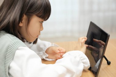 Japon öğrenci yemek odasında tablet bilgisayar kullanıyor (8 yaşında)) 