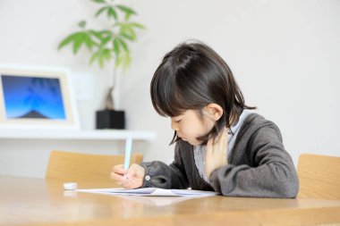 Japon öğrenci kız öğrenci yemek odasında okuyor (8 yaşında))