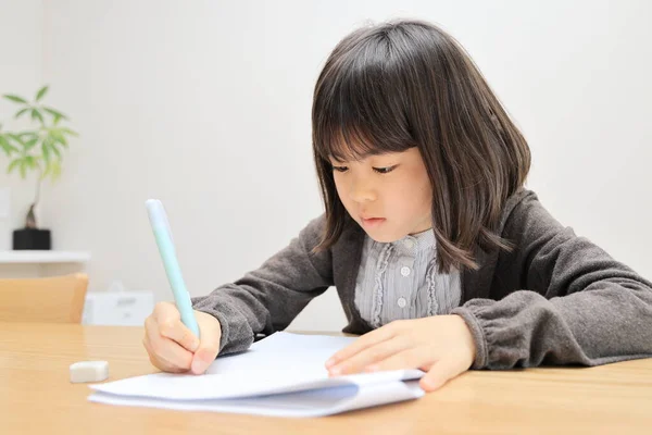 Japanese student girl studying in dining room (8 years old)