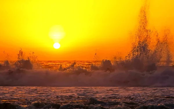 海の地平線上に美しい明るい鮮やかな黄色のオレンジの夕日 野生のサーフィン 高くそびえる波を飛び散らせます うめき声 — ストック写真