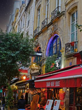 Paris (Quartier Latince), Fransa - 9 Kasım. 2022: Geceleri güzel, eski, renkli, romantik bir restoran, yeşil ağaçlar ve bitkiler, tente