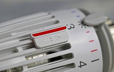 İzole edilmiş beyaz manuel ısıtıcı termostatı, ısıtma maliyetlerini düşürmek için 3. seviye sıcaklıkta kırmızı klipsli termostat ile kapatıldı - Almanya