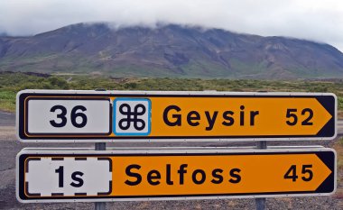 Yellow road signs showing direction and distance to Geysir and town Selfoss - Iceland