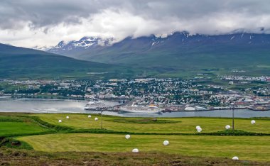 Akureyri, Iceland - July 9. 2008: Icelandic town at fjord with cruise ship harbor, mountains background
