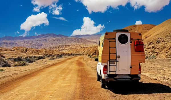 Camper truck trip on red dirt track sand road, barren lonely wild desert valley - Chile, Atacama region, Pan de Azucar NP