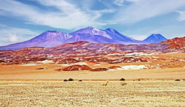 Gerçeküstü hayat düşmanca çöl manzarası, kuru kum düzlüğü, renkli turuncu renkli tepeler, volkanik dağlar - Salar de Atacama, Şili