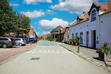 Oud Bergen, Hollanda - 9 Haziran. 2023: Hollanda 'da boş bir cadde uykulu kırsal köy, mavi yaz gökyüzü