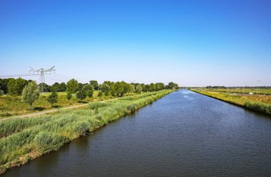 Hollanda 'nın iç kesimlerinde güzel bir su kanalı, yeşil kırsal alan, nehir kenarı bisiklet yolu, Kuzey Brabant. S-Hertogenbosch yakınlarında, Hollanda