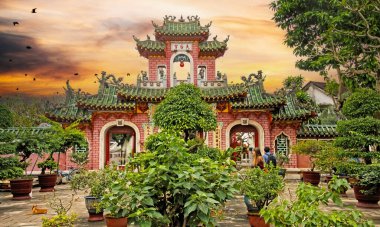 Hoi An (Hoi Quan Phuoc Kien), Vietnam - 9 Aralık. 2015: Gizemli günbatımı gökyüzüne sahip güzel Vietnam tapınağı bahçesi