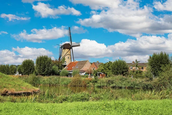 Tipik güzel, huzurlu Hollanda kırsal arazisi, eski yel değirmeni, göl ve yeşil çayır ile küçük bir köy - Breda, Hollanda yakınlarındaki Terheijden, Brabant