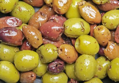 Çeşitli turşu turşusu Akdeniz baharatlarının yakın planında Yunan yeşili, kırmızı ve siyah zeytinler vardı.