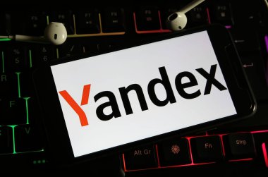 Viersen, Almanya - 9 Aralık. 2023: Bilgisayar klavyesinde Yandex şirketinin logosuyla akıllı telefonun kapatılması