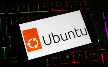 Viersen, Almanya - 9 Aralık. 2023: Bilgisayar klavyesindeki akıllı telefonun Ubuntu logosu ile kapatılması