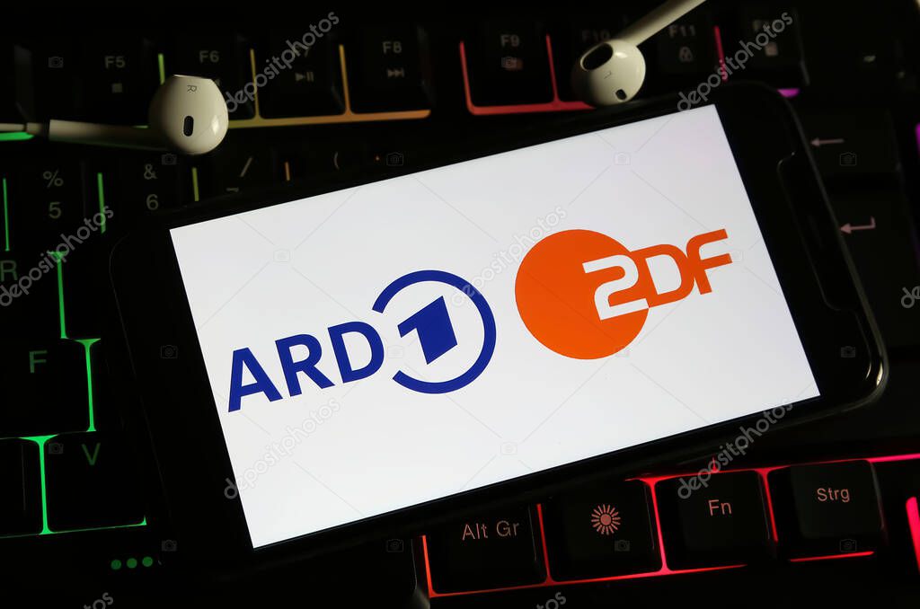 Viersen, Germany - December 9. 2023: Closeup of smartphone on computer keyboard with logo lettering of german public television channels ARD and ZDF